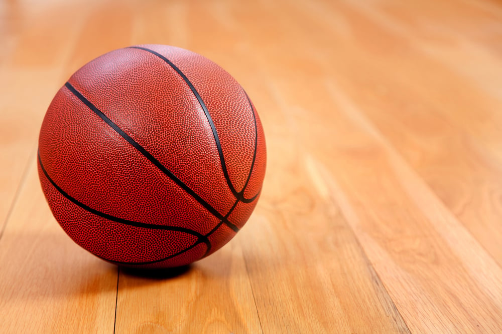 Image of a basketball lying on a wooden floor